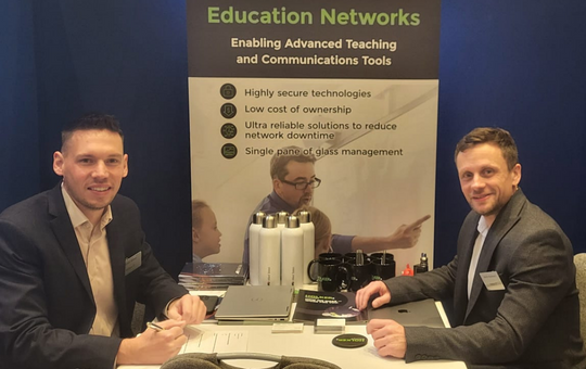 Dan and Martin seated at their stand at the Education Forum event
